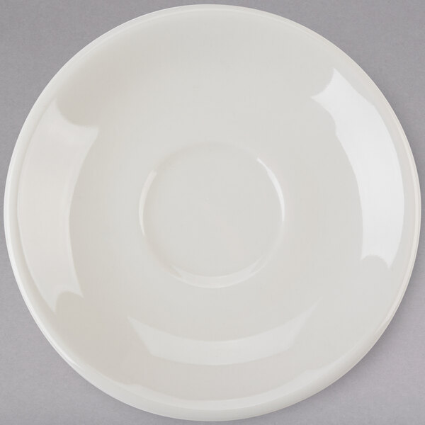 A white Tuxton Reno saucer with a circle on a gray surface.