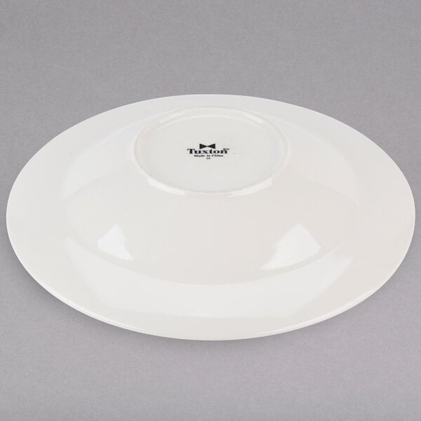 A white Tuxton pasta bowl with a black rim.