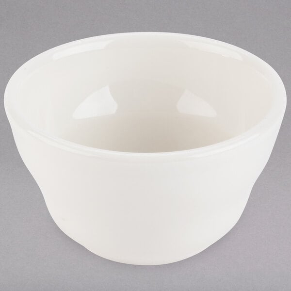 A Tuxton eggshell white china bouillon cup on a gray surface.