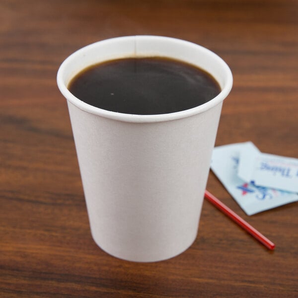 A Solo paper hot cup of coffee with a red straw on a table.