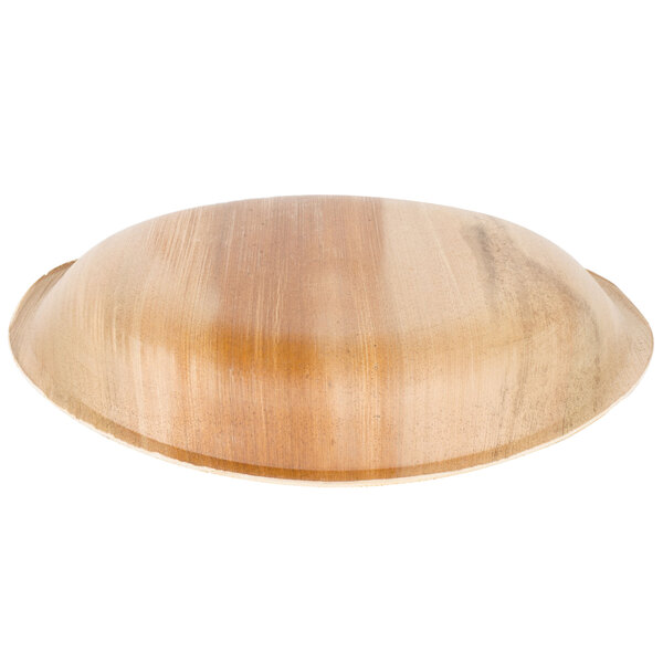 A close-up of an EcoChoice palm leaf plate on a wood surface.