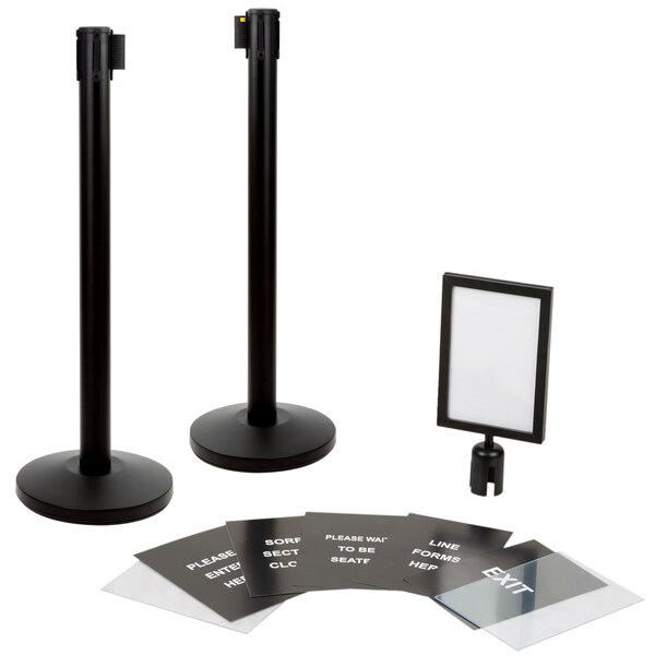Two black Lancaster Table & Seating metal crowd control stanchions with clear sign covers.