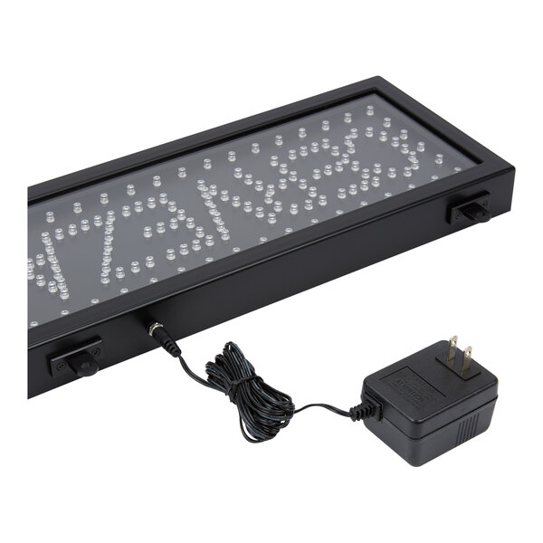 A rectangular LED sign with a black frame and a connected power adapter.