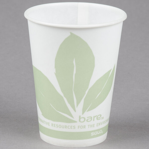 A white paper cup with green leaves on it.