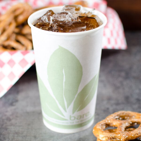 A Bare by Solo paper cold cup with ice in it on a table with pretzels.