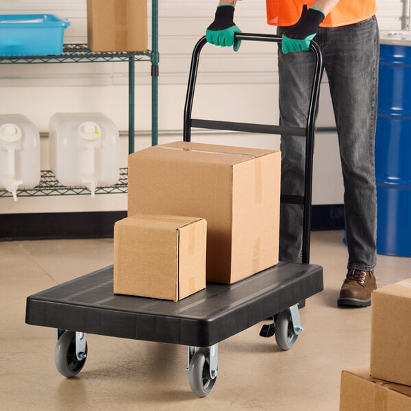 A heavy duty platform truck with an ergonomic handle carrying cardboard boxes.
