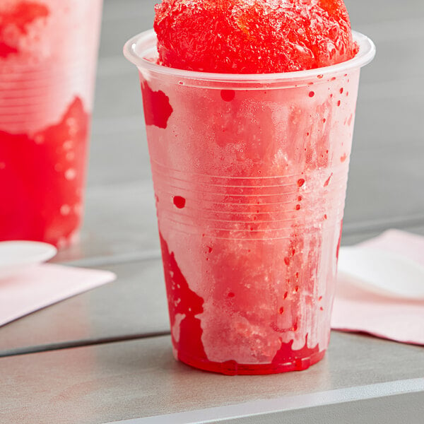 A red drink in a translucent plastic cup with a straw.