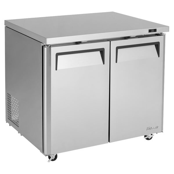 A silver stainless steel Turbo Air undercounter refrigerator with two doors.