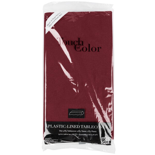 A red Creative Converting table cover in a plastic bag with the words "Burgundy Tissue / Poly Table Cover" in white.