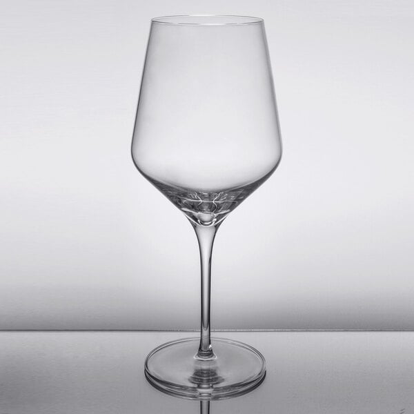 A close-up of a Reserve by Libbey Prism wine glass with a clear rim on a table.