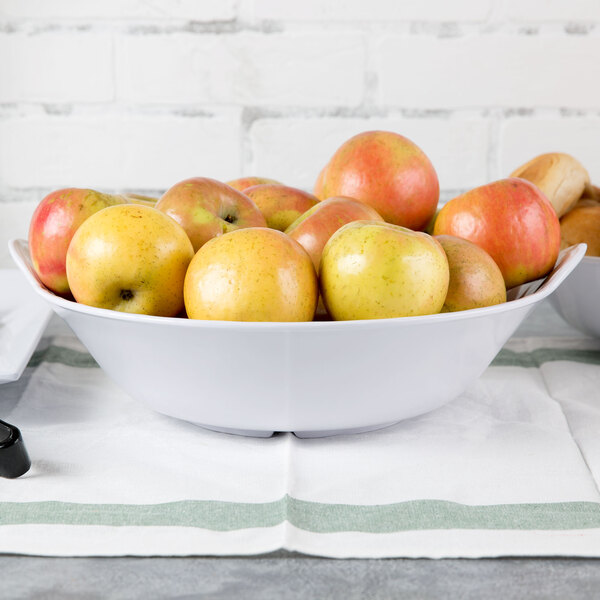 A white GET Siciliano bowl filled with yellow apples.