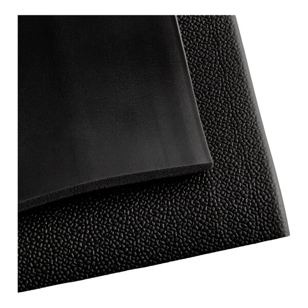 A close-up view of a black mat with a smooth surface on one side and a pebbled texture on the other.