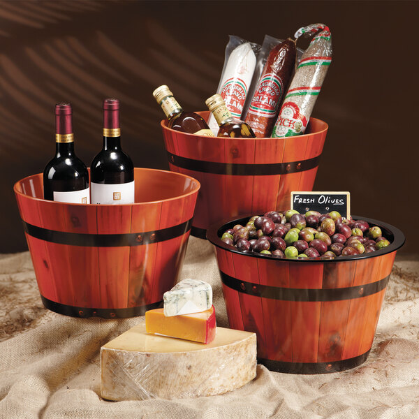 Three melamine barrels of wine with olives on a table.