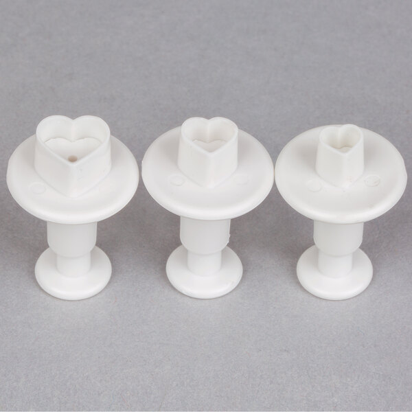 A white plastic Ateco 3-piece pastry cutter set with heart shapes.