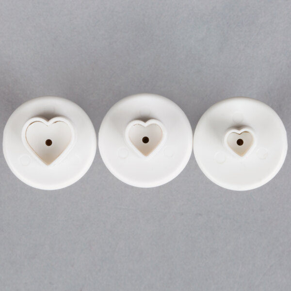 A set of three white plastic heart-shaped pastry cutters.