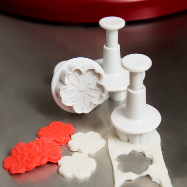 A white Ateco plastic cookie cutter with a flower design.