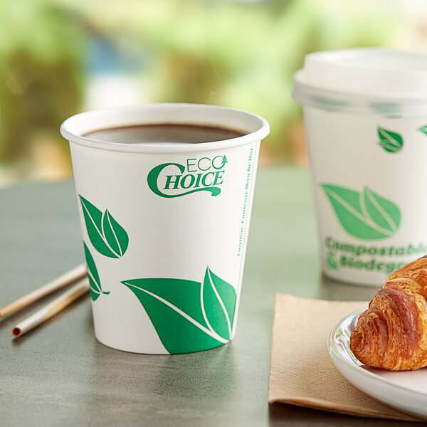 A close-up of an EcoChoice leaf print paper hot cup filled with coffee on a table.
