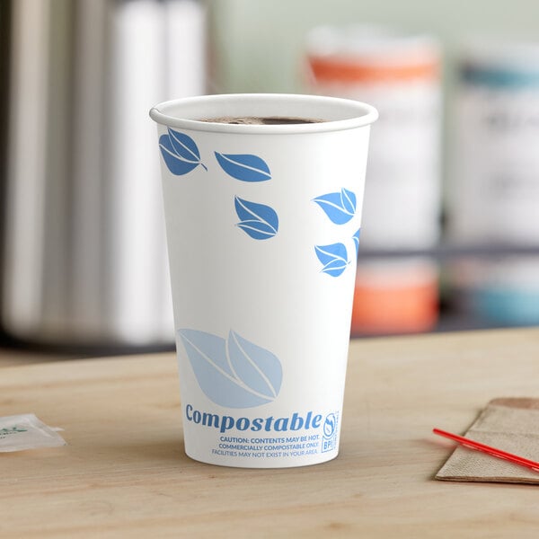 A close-up of a white EcoChoice paper hot cup with blue leaves on it.