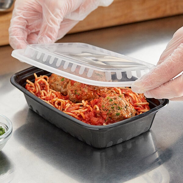 black plastic take out container with spaghetti and meatballs