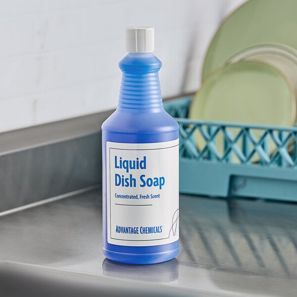A blue bottle of Advantage Chemicals Concentrated Liquid Dish Soap with a white label on a countertop next to plates.