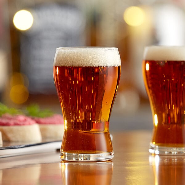 Two Libbey mini pub beer tasting glasses on a table with food.