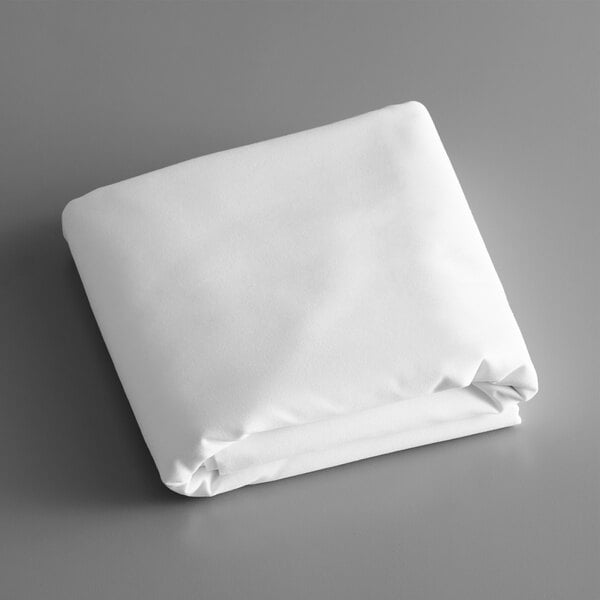 A folded white Intedge tablecloth on a gray surface.
