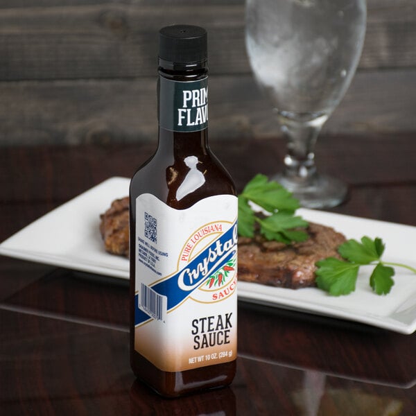 A Crystal steak sauce bottle on a white plate.