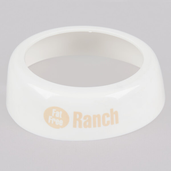 A white plastic Tablecraft dispenser collar with beige lettering that says "Fat Free Ranch"