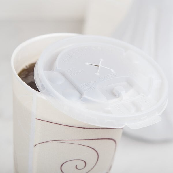 A Solo translucent plastic lid with lift and lock tab and straw slot on a coffee cup.