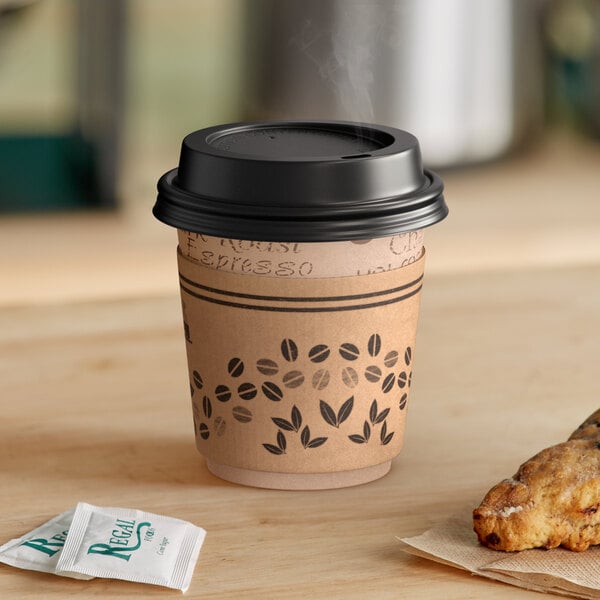 A Choice paper hot cup with a black lid and a cookie on a table.