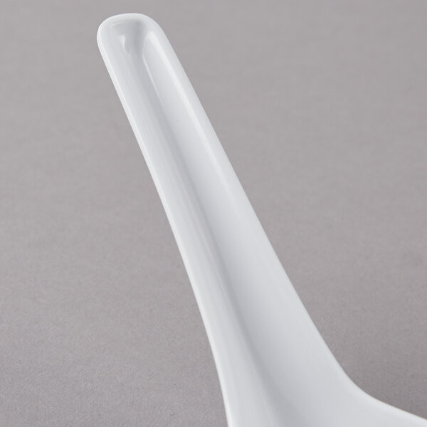 A close-up of a white GET Melamine soup spoon with a long handle.