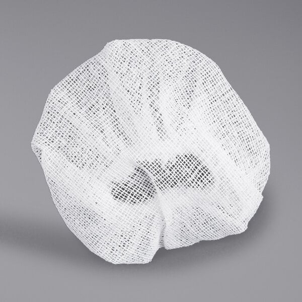 A close-up of a white mesh bag with a small hole in it.