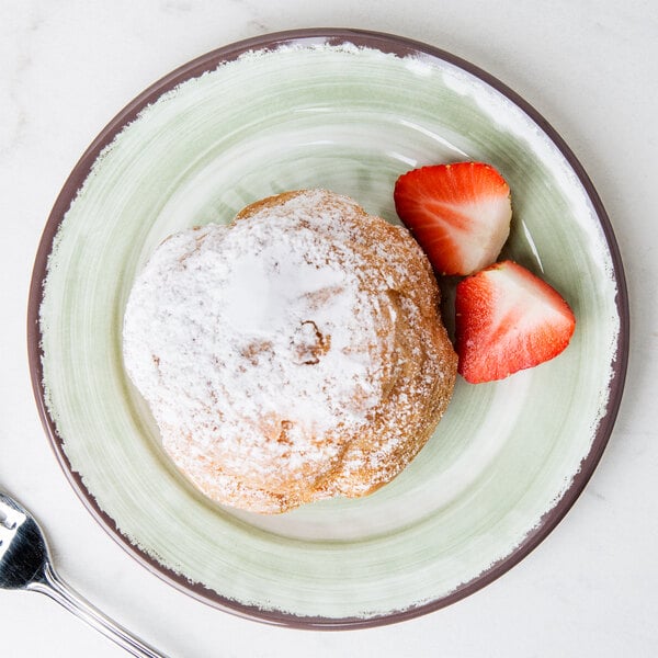 A Carlisle jade melamine bread and butter plate with a pastry and strawberries on it.