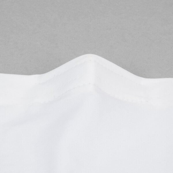A close-up of a white fabric with a folded edge.