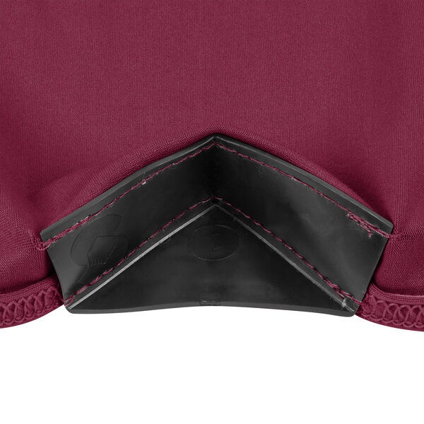 A close up of a burgundy spandex fabric with black leather corners.