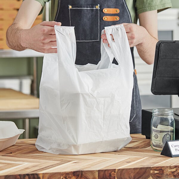 A person holding a white plastic bag.