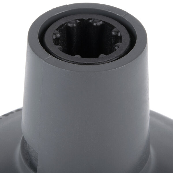 A close-up of a grey plastic nut with a hole in it.