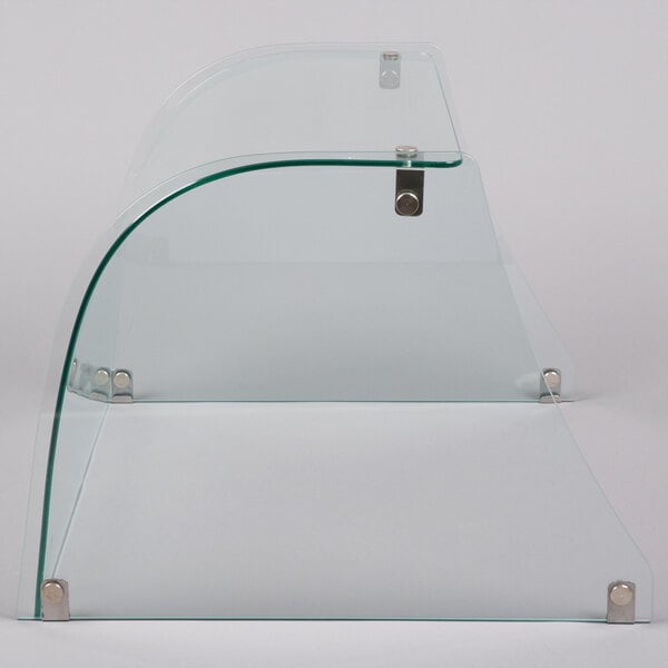 A curved glass sneeze guard with metal corners.