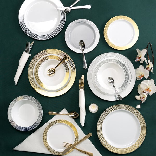 A table setting with a white Visions plastic plate with a silver lattice design, a fork, and a knife.