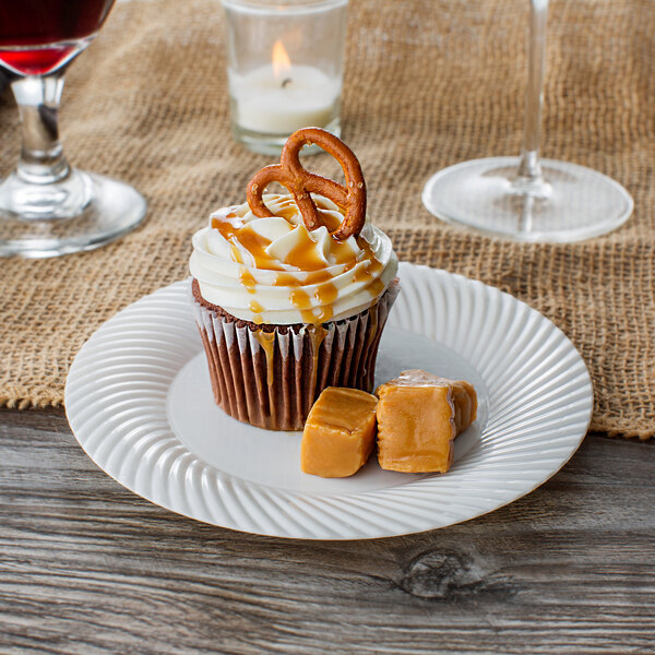 A cupcake on a Visions Wave bone plastic plate with a pretzel on top.