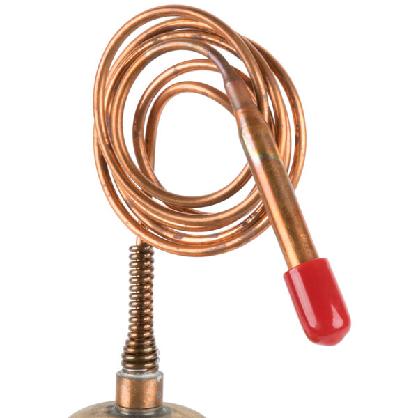 A copper water regulator with a red handle.