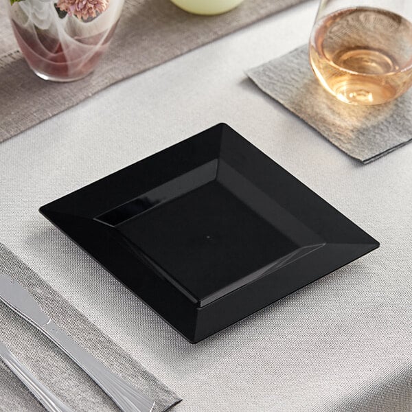 A black square Visions Florence plastic plate on a table.