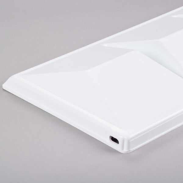 A white rectangular plastic baffle with a square design on top.