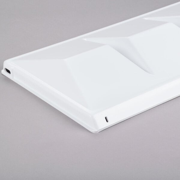 A white rectangular plastic baffle with a square design.