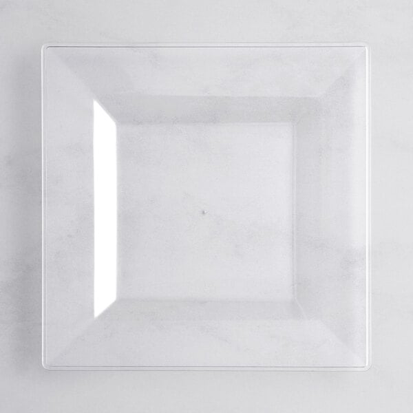 A clear square plate on a white surface.