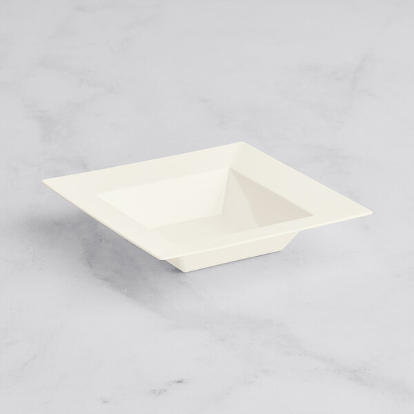 A white square bowl on a marble surface.
