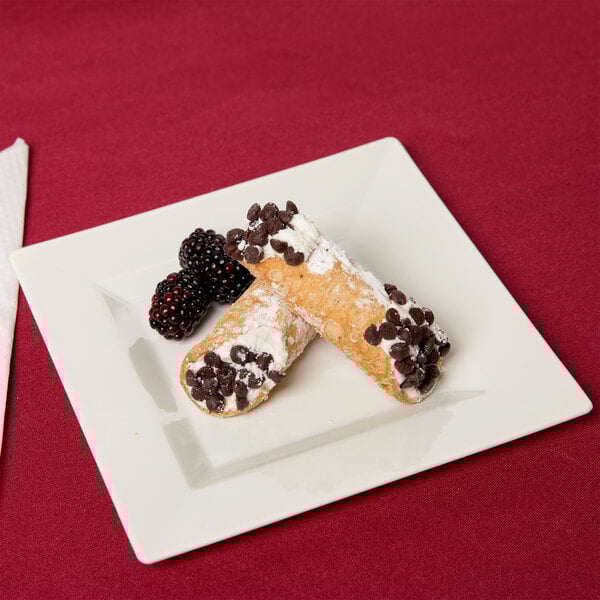 A Visions Florence ivory plastic plate with a pastry and berries on it.