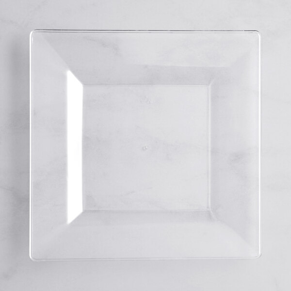 A clear square Visions Florence plastic plate on a white surface.