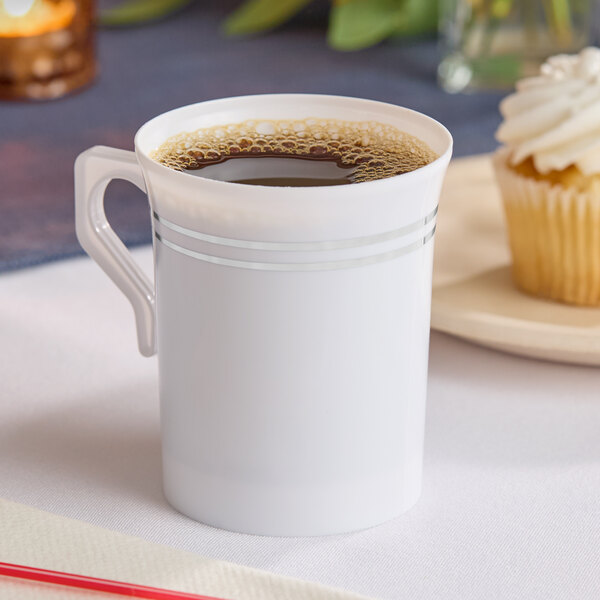 A white plastic coffee mug with silver bands filled with coffee.
