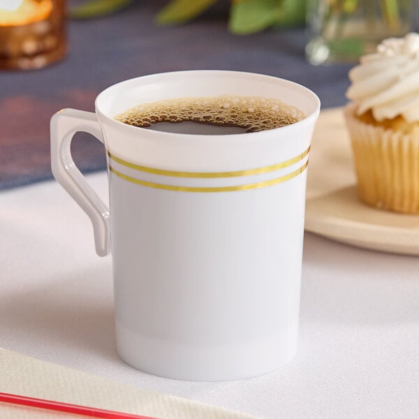 A white plastic coffee mug with two gold bands near the rim, filled with coffee.